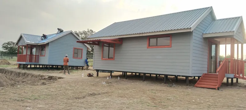 Two grey Nutec homes with metal roofs raised on poles
