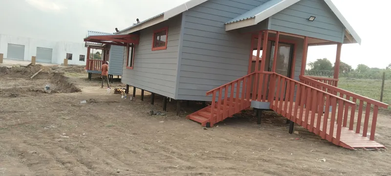 Grey Nutec house with a red timber veranda and access ramp
