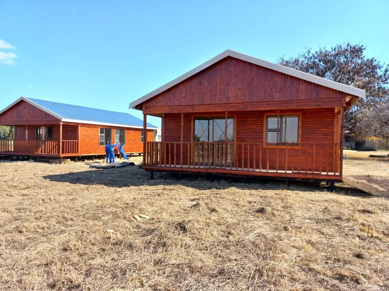 Stained timber log home with a veranda and pitched roof