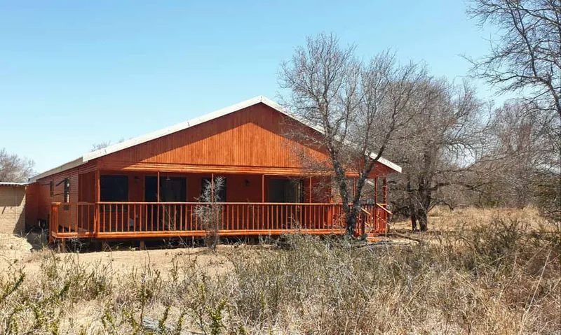 Stained timber log home with a long covered veranda