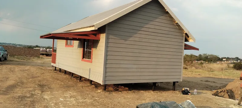 Grey and cream Nutec cottage with a pitched roof on raised poles