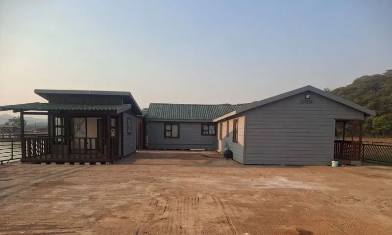 Row of grey Nutec units with covered porches on a cleared site